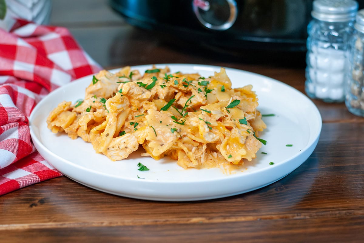A serving of buffalo chicken mac and cheese on a white plate. 