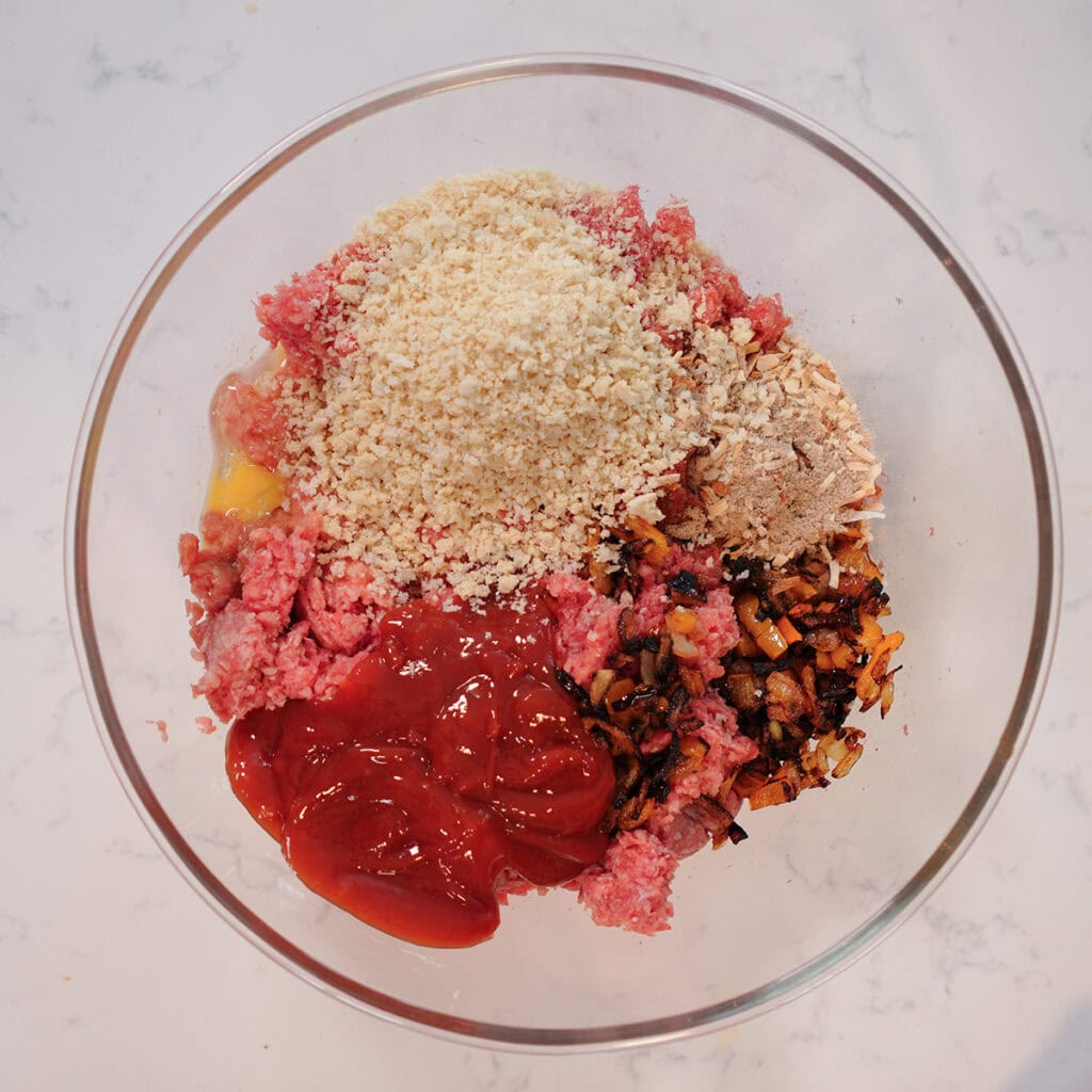 breadcrumbs, meat, onions and peppers in a bowl.