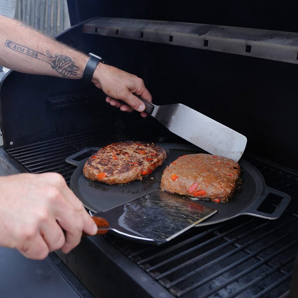 grilled meatloaf being flipped on a grill pan.