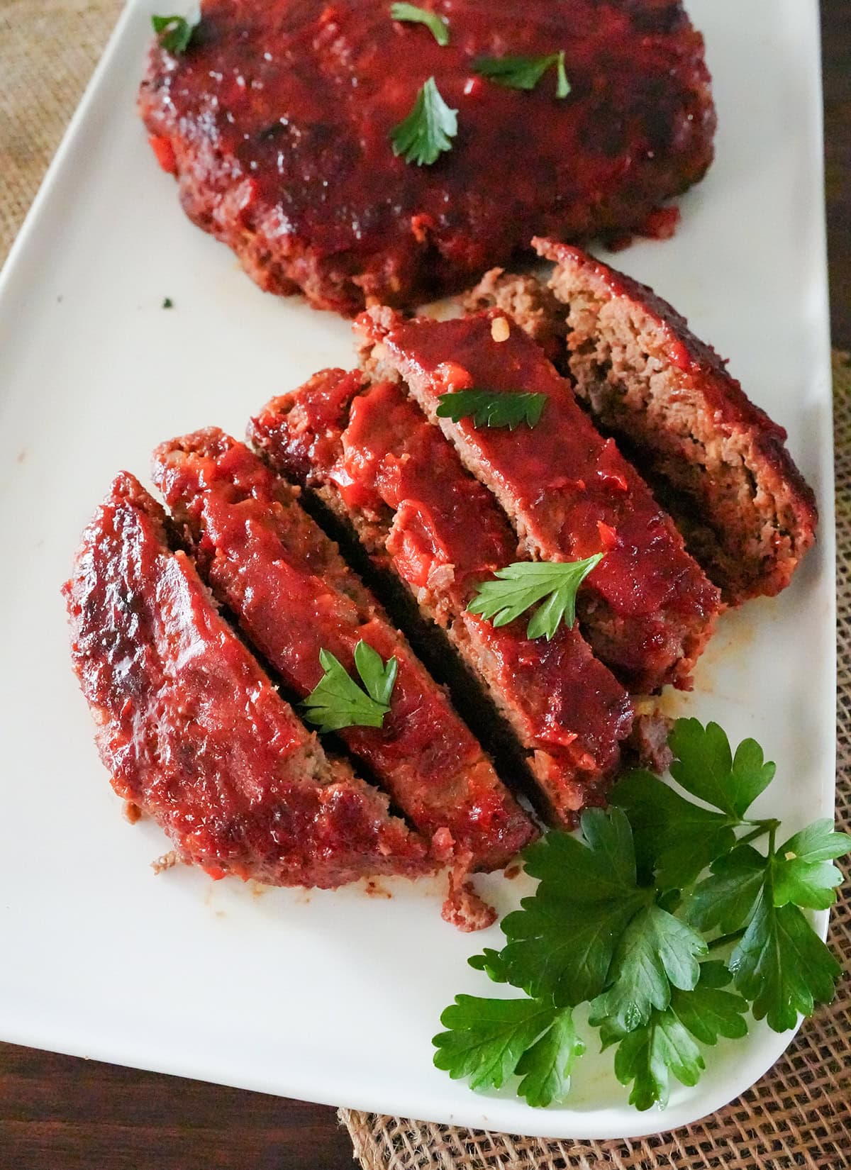 grilled meatloaf on a plate with parsley.