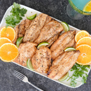 grilled margarita chicken with orange and lime slices.