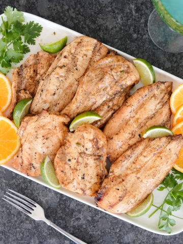 grilled margarita chicken with orange and lime slices.