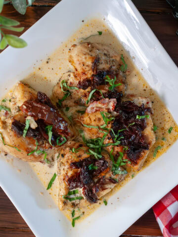 Crock pot marry me chicken on a plate with sun dried tomatoes.