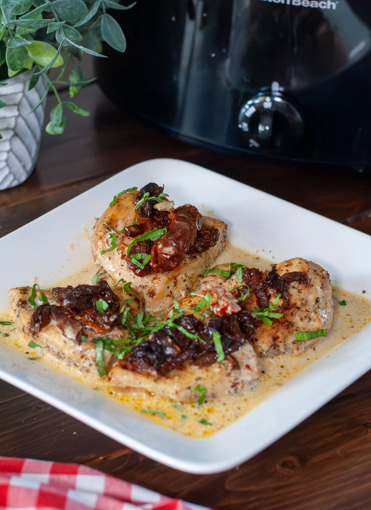 A photo of a finished plate of Marry Me Chicken showing sun dried tomatoes and fresh basil on top. 