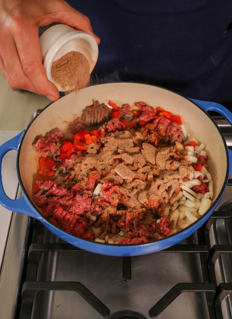 The taco seasoning being put in a skillet. 