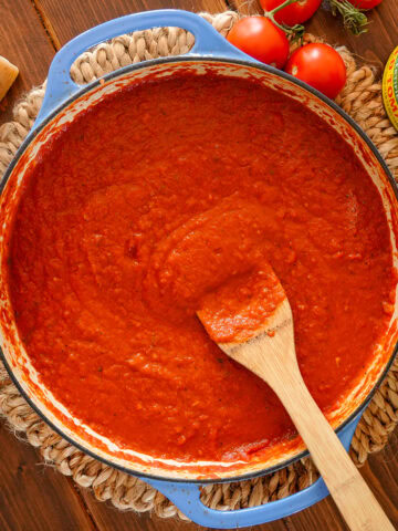 Tomato sauce in a blue dish with san marzanos tomatoes.