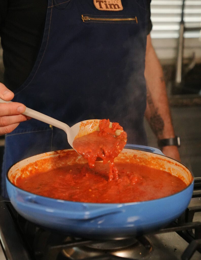 A finished scoop of tomato sauce in a spoon. 