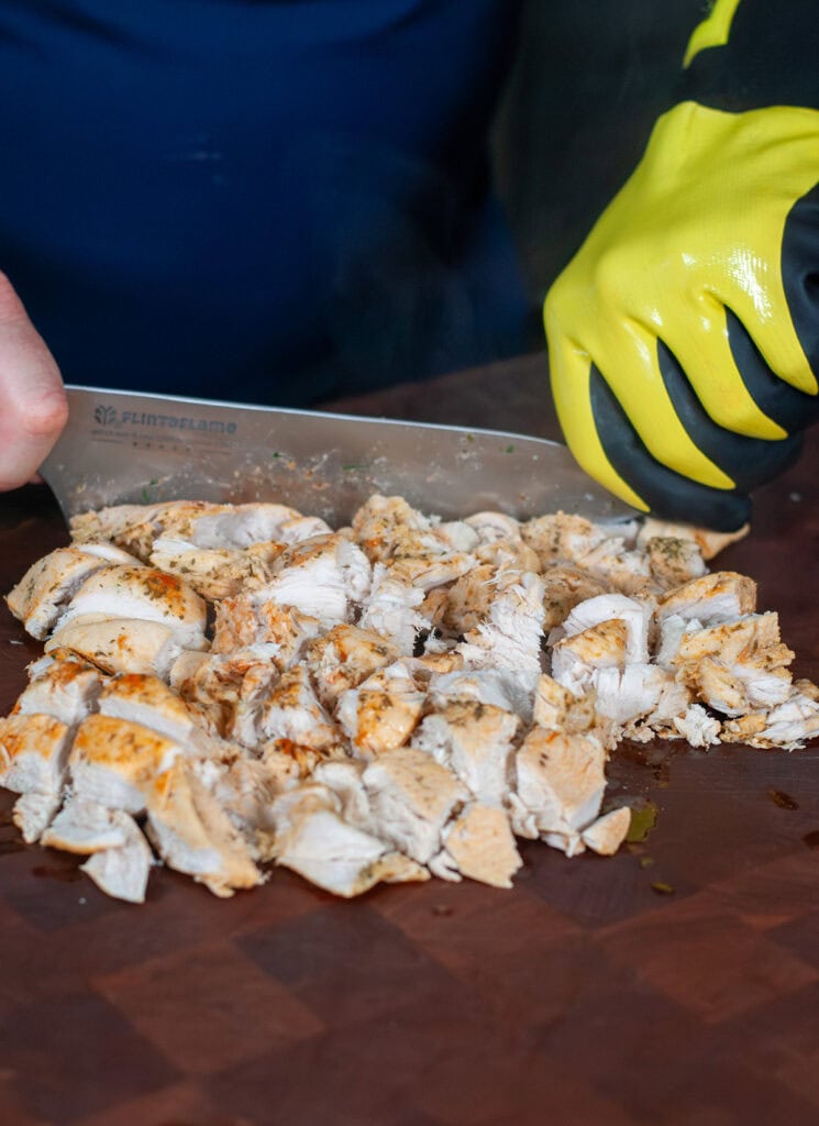 Diced chicken on a wooden cutting board. 