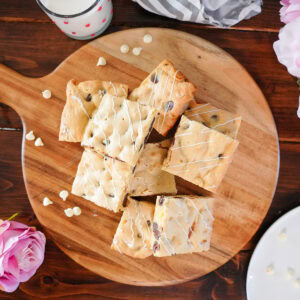 chocolate and white chocolate brownies piled on a wooden board.