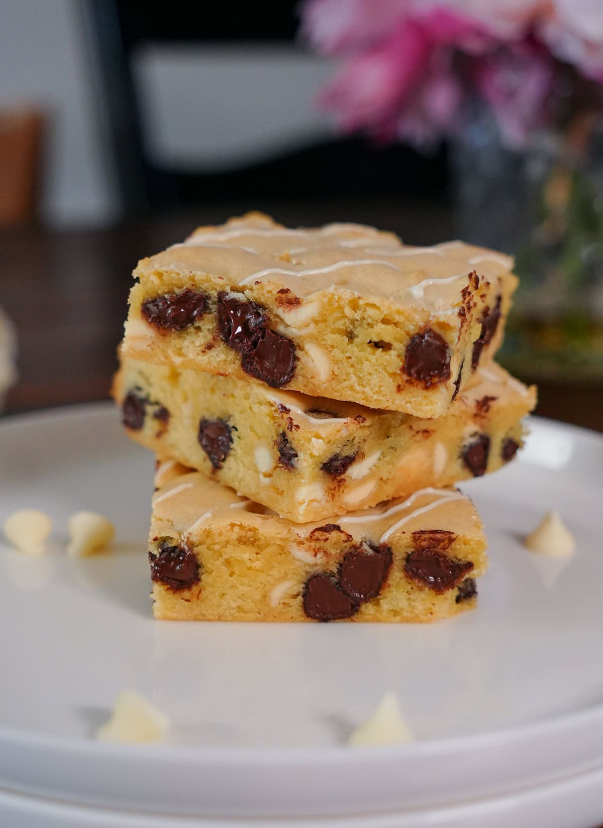 A stack of white chocolate brownies showing white and chocolate chips. 