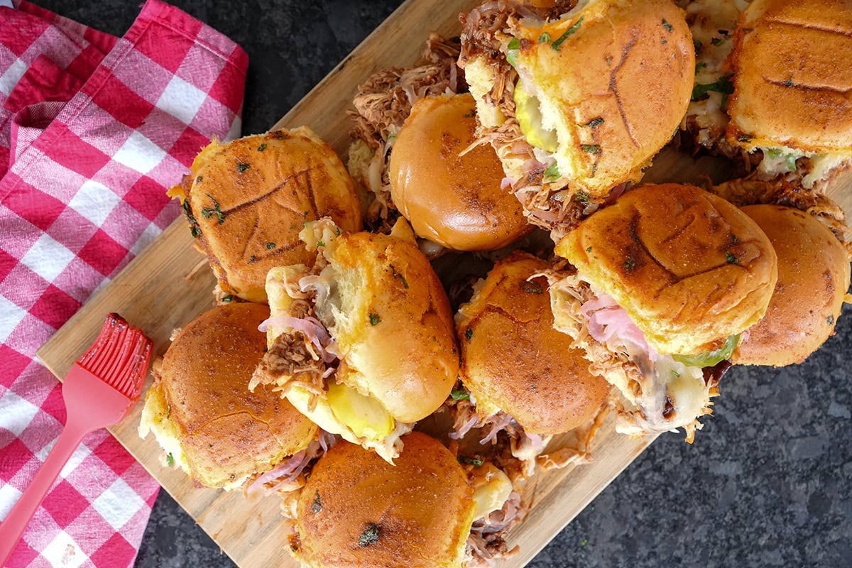 A top view of BBQ Chicken Sliders showing pickled onions and melted cheese.
