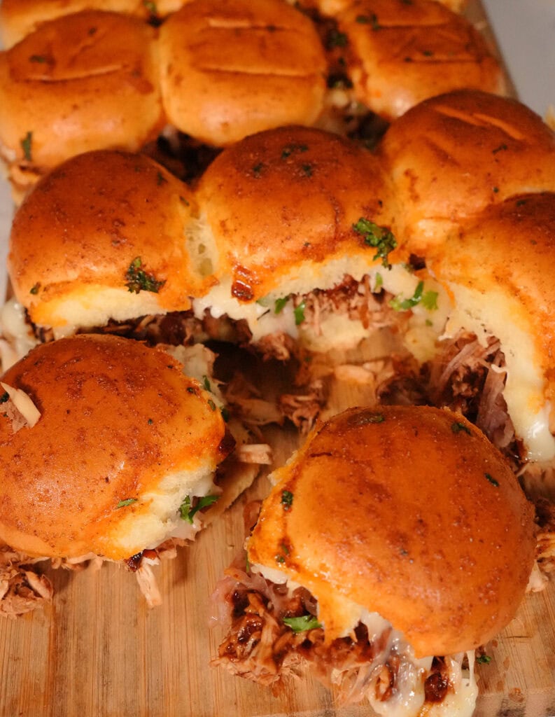 Finished BBQ Chicken Sliders on a wooden board ready to eat.