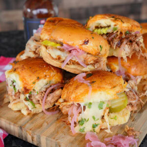 Chicken sliders with bbq sauce and pickles.