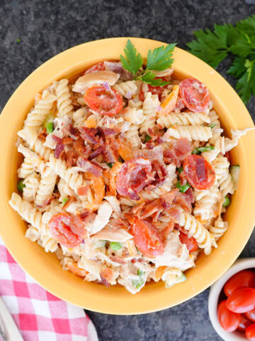 pasta salad with chicken, bacon, ranch and peppers topped with parsley.
