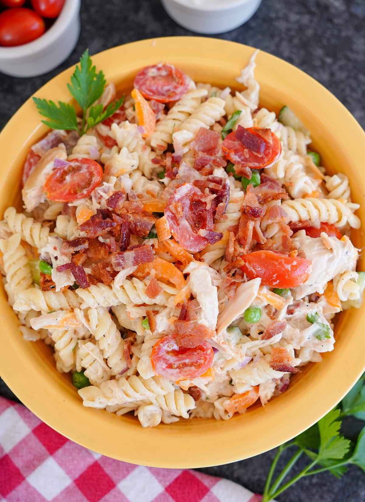A top view of Chicken Bacon Ranch Pasta Salad showing bacon and fresh parsley.