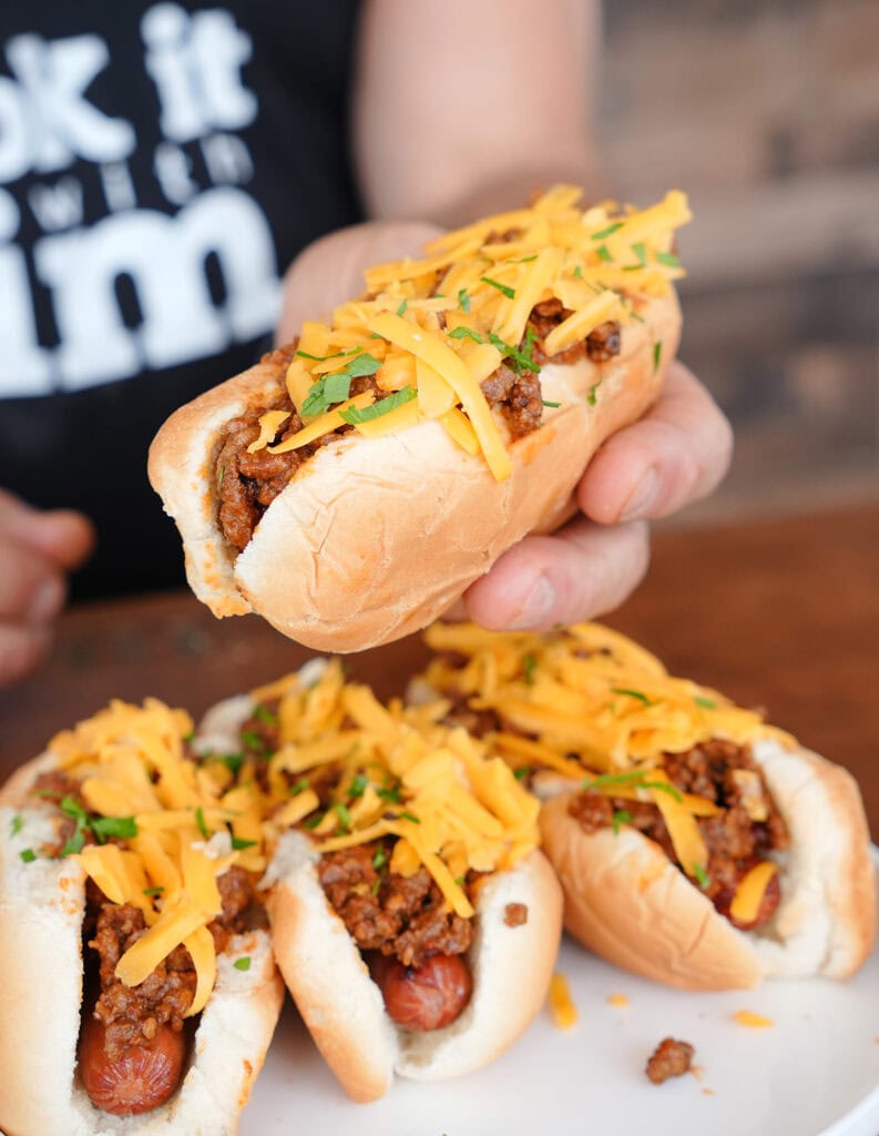 4 chili cheese dogs on a plate. 
