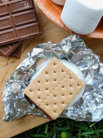 Grilled smore on a board with a chocolate bar.