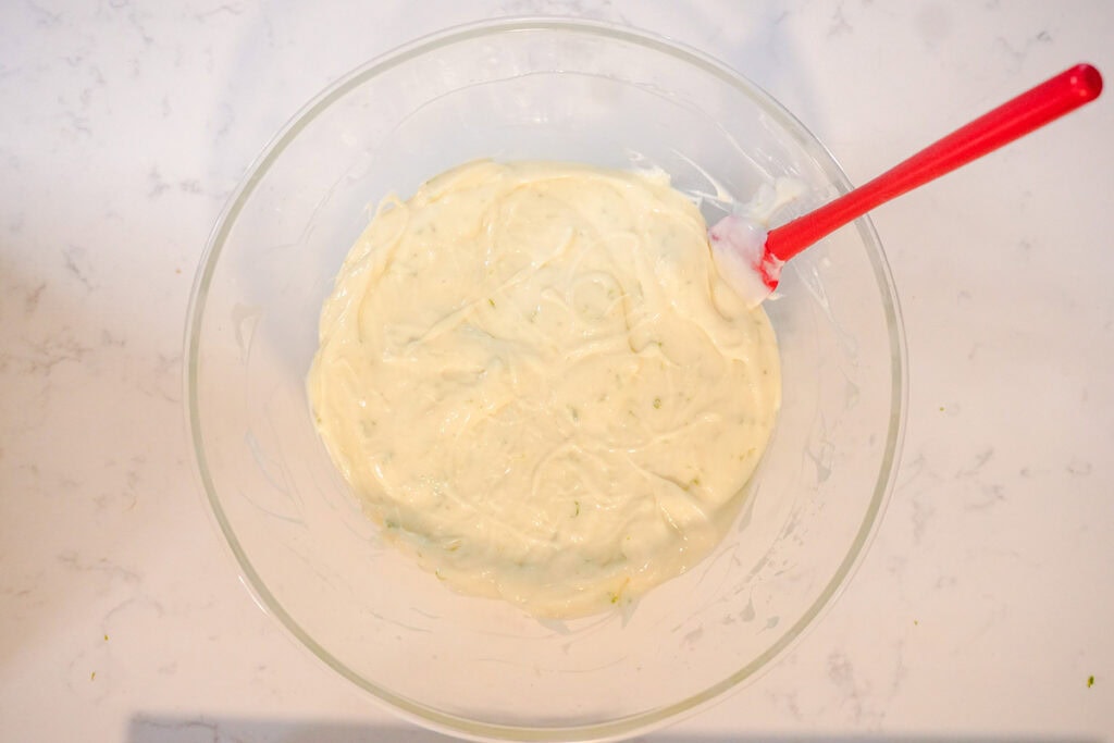 The lime filling for key lime bars in a mixing bowl. 