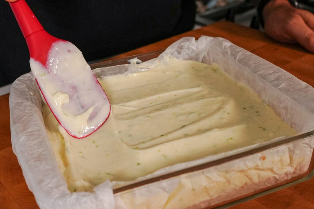 The lime filling in an 8x8 dish with a spatula. 