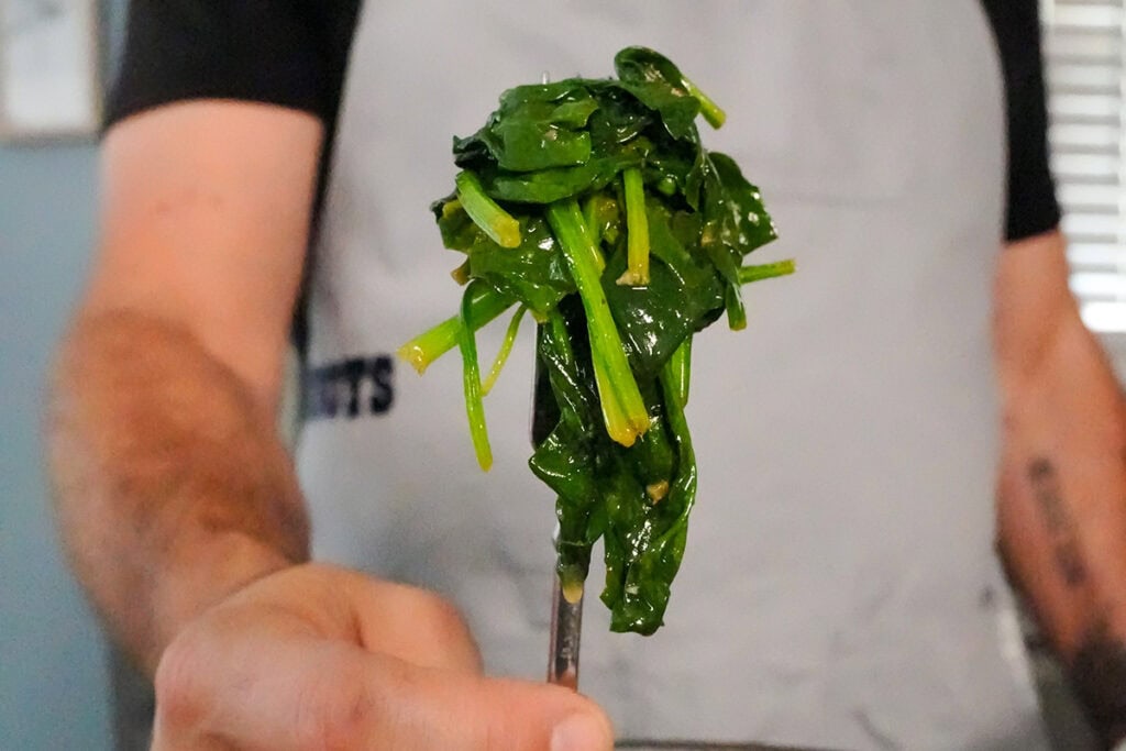 A forkful of cooked spinach.