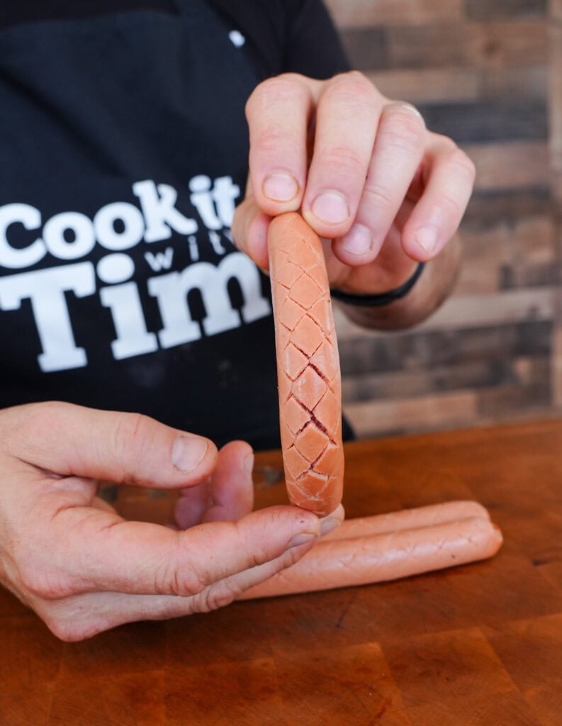 A crosshatch pattern cut into a hot dog.