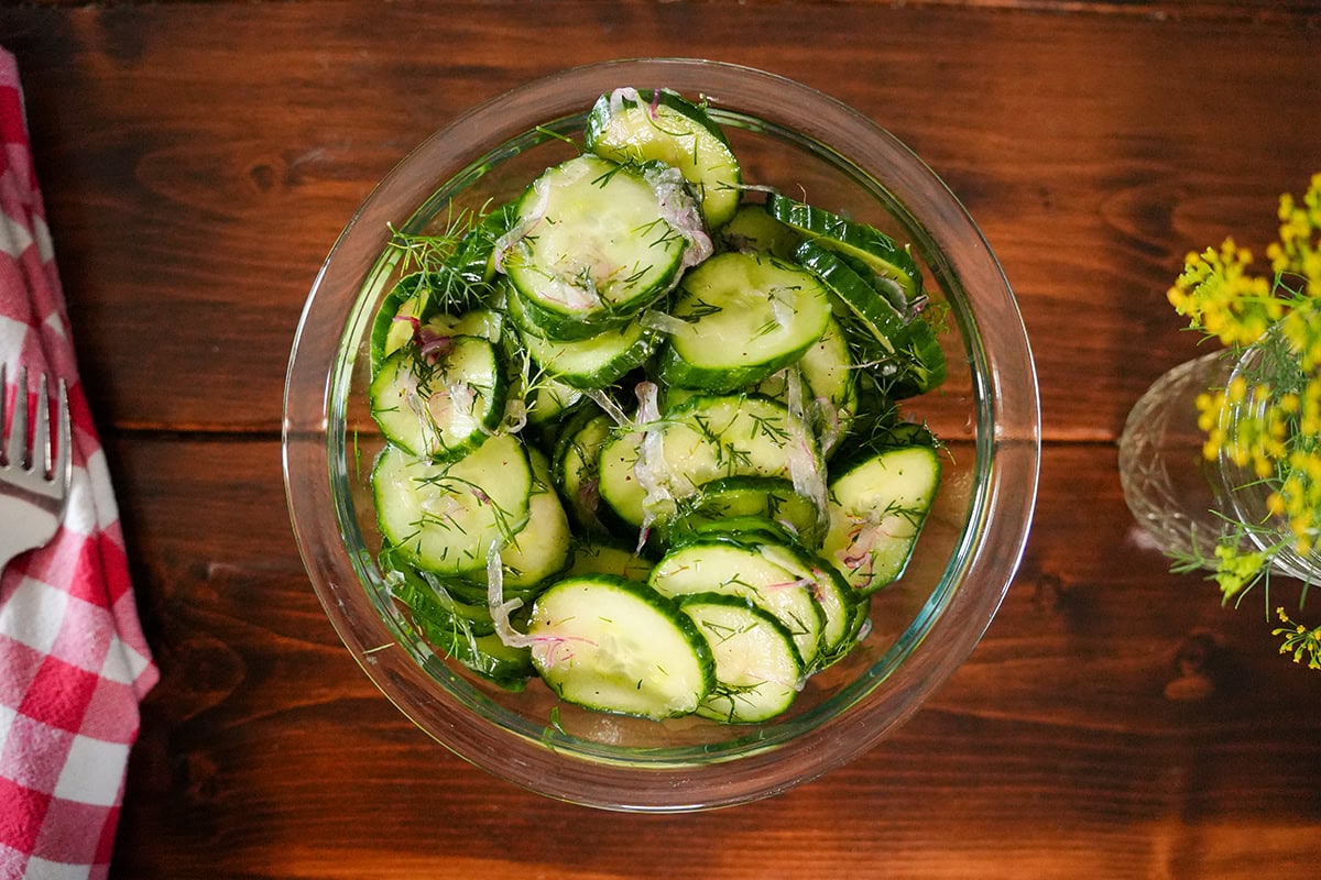 cucumber and dill salad topped with fresh dill and onions.