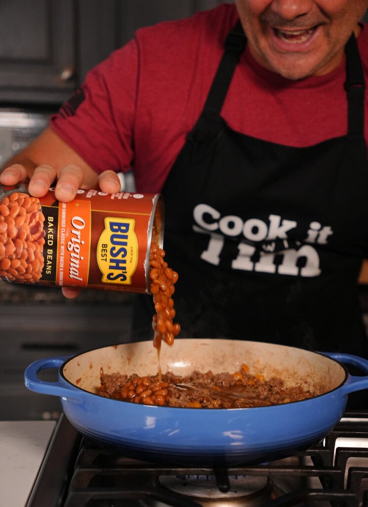 bush's baked beans pouring into a dutch oven.