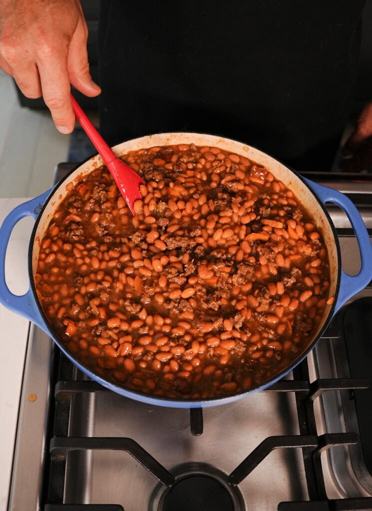 baked beans and hamburger meat being mixed together.