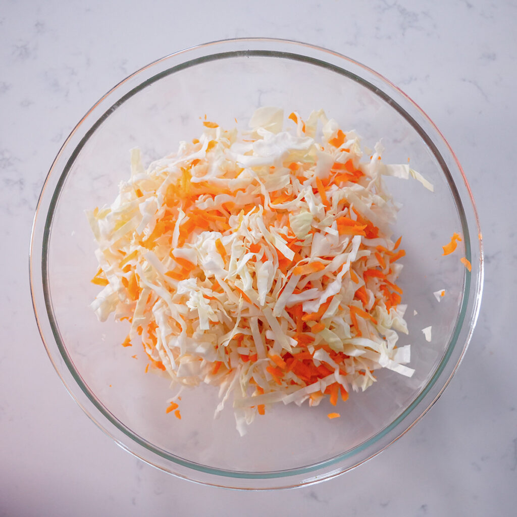 a bowl of shredded carrots and cabbage.