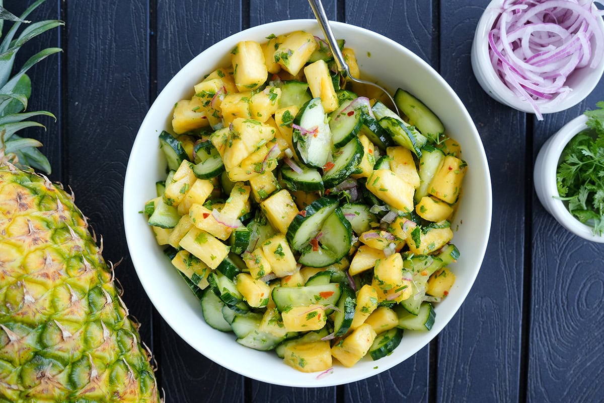 Pineapple and cucumber salad with onions and lime zest.