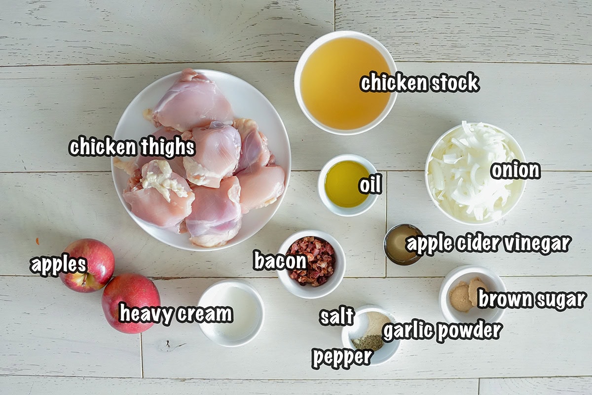 Ingredients for making a chicken and apple dinner in a skillet.