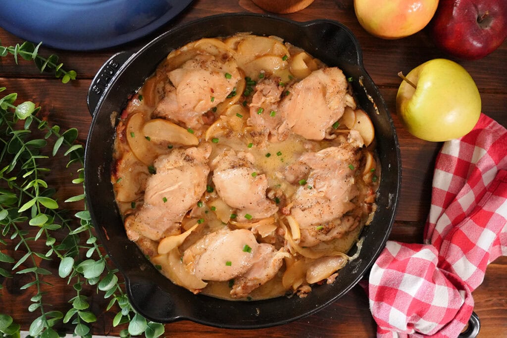 apples and chicken served in a skillet with chives.