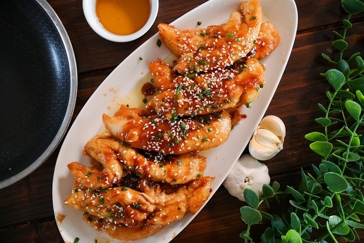 chicken tenders with honey garlic glaze, sesame seeds and chives.