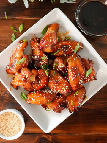 teriyaki chicken wings with sesame seeds and chives.