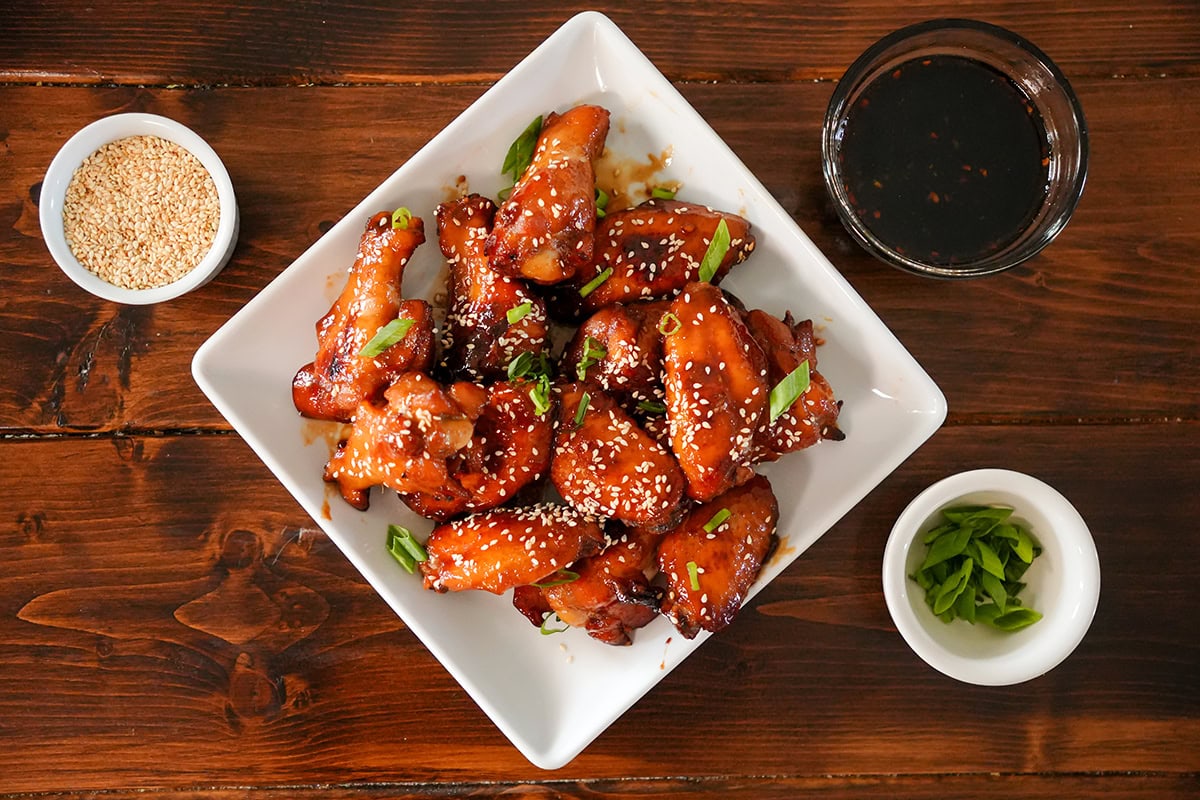 chicken wings with teriyaki glaze and toppings.