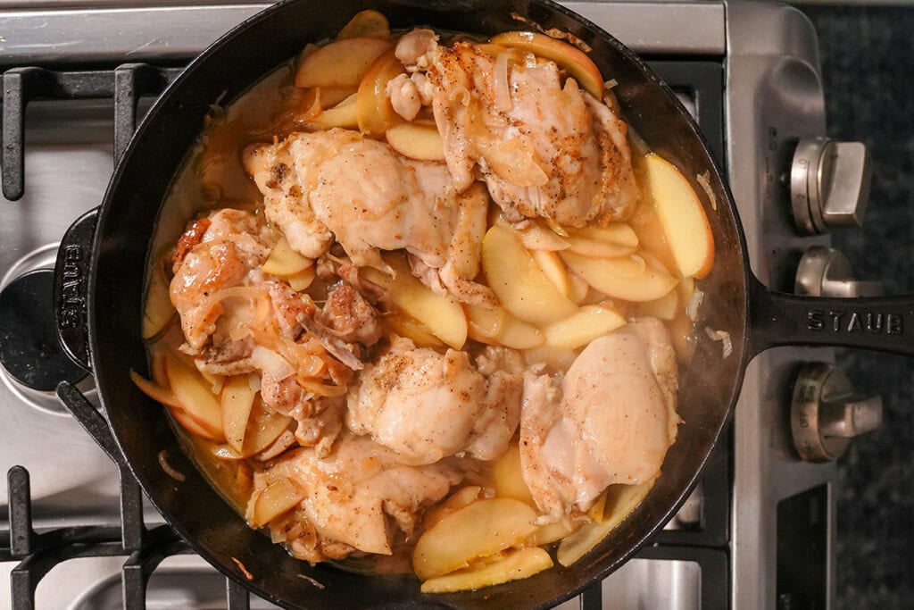 chicken thighs and apples cooking in chicken broth.