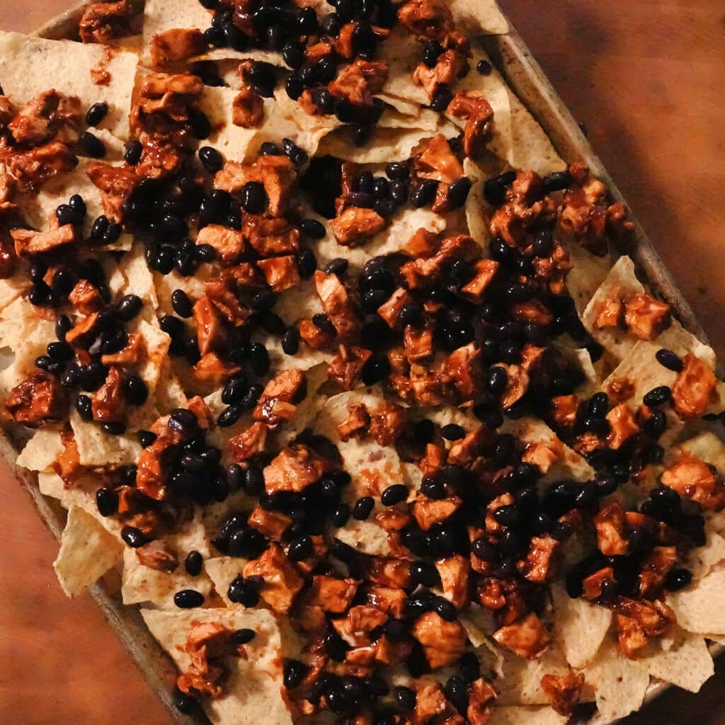 black beans and bbq chicken on top of tortillas.