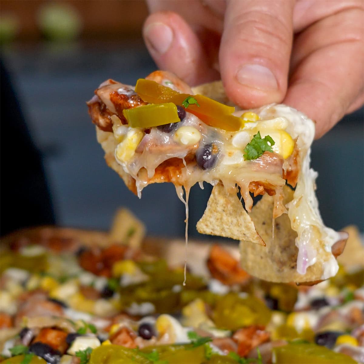 A nacho chip full of jalapeño, cheese and bbq chicken.