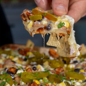 chicken nachos with bbq sauce and fresh vegetables.