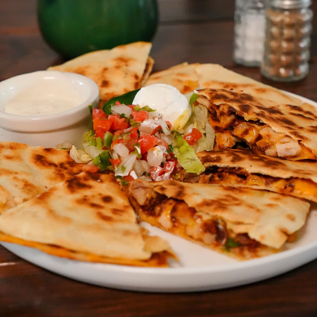 a chicken bacon and ranch quesadilla cut into pieces.