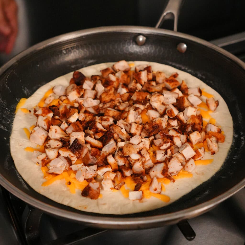 chicken over cheese on a tortilla.