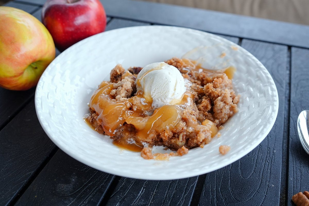 apple dump cake with ice cream and caramel syrup.