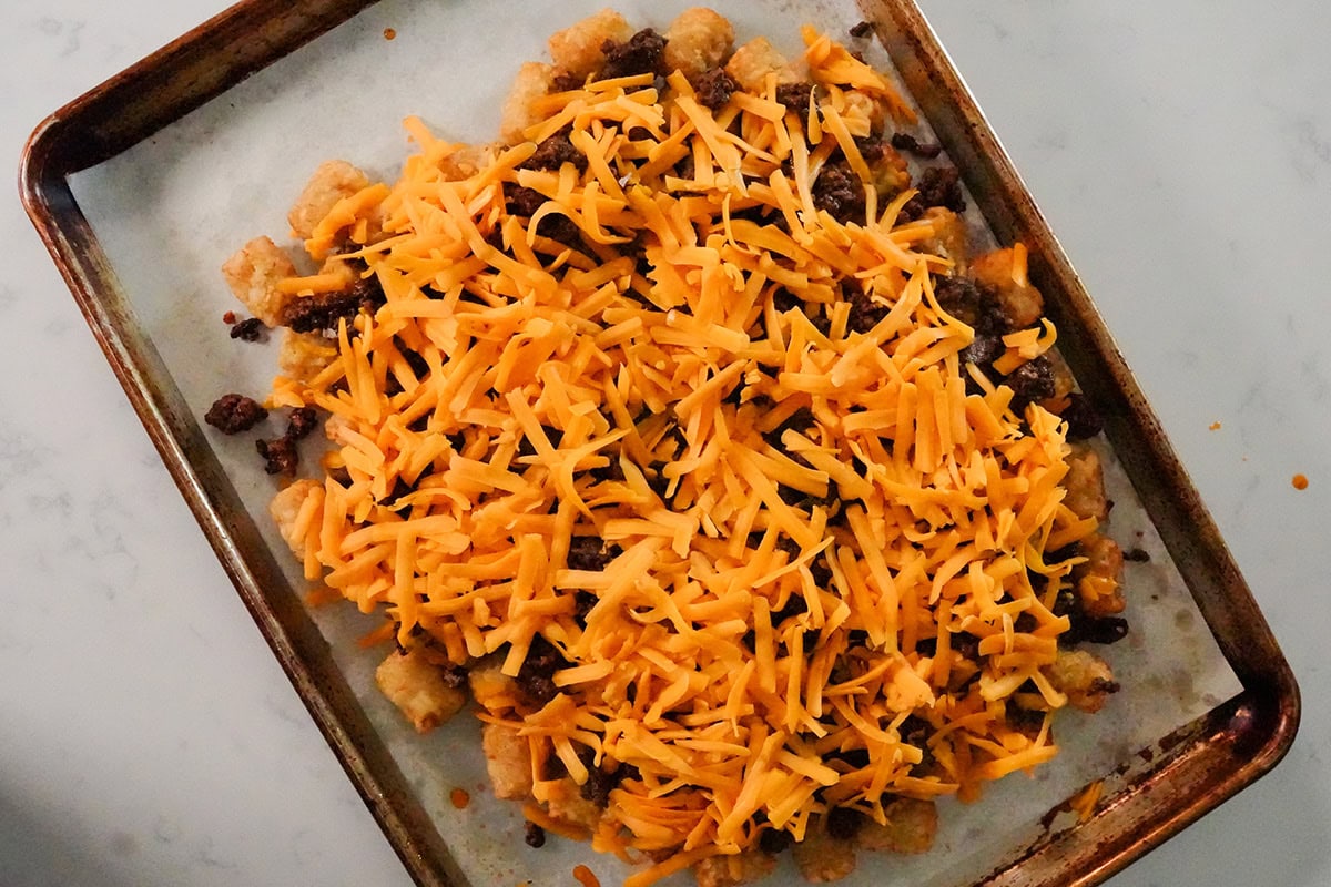 cheese, beans and taco meat on top of tater tots.