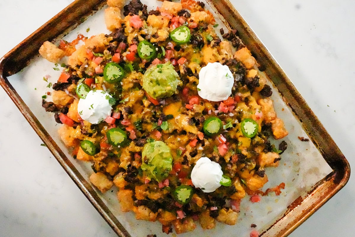 guacamole, sour cream and jalapeños on top of totchos.