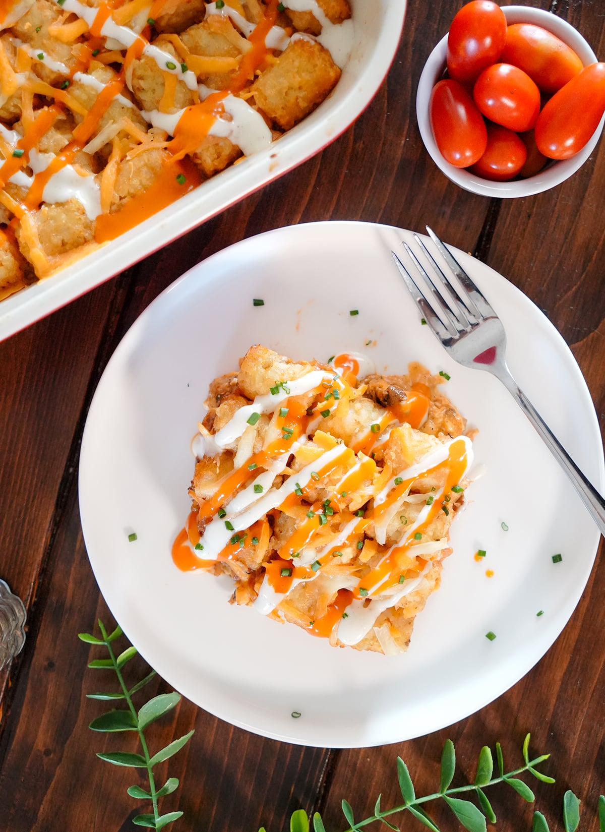 buffalo chicken in a casserole dish with tater tots and ranch dressing.
