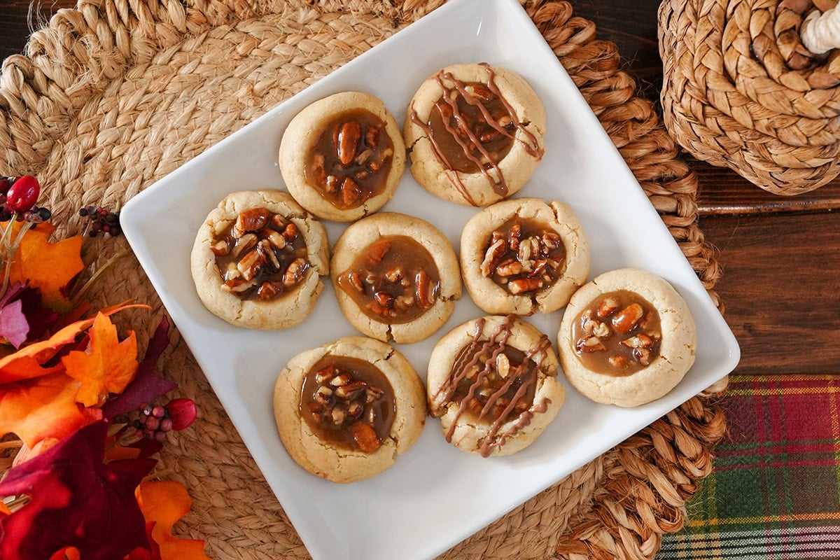 pecan pie cookies with a chocolate drizzle on a plate.
