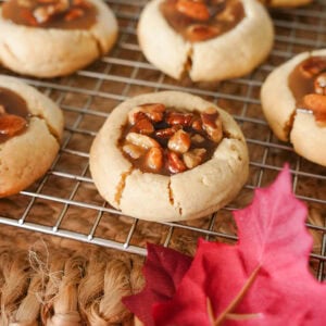 pecan pie cookies on a cooking rack and fall leaves.