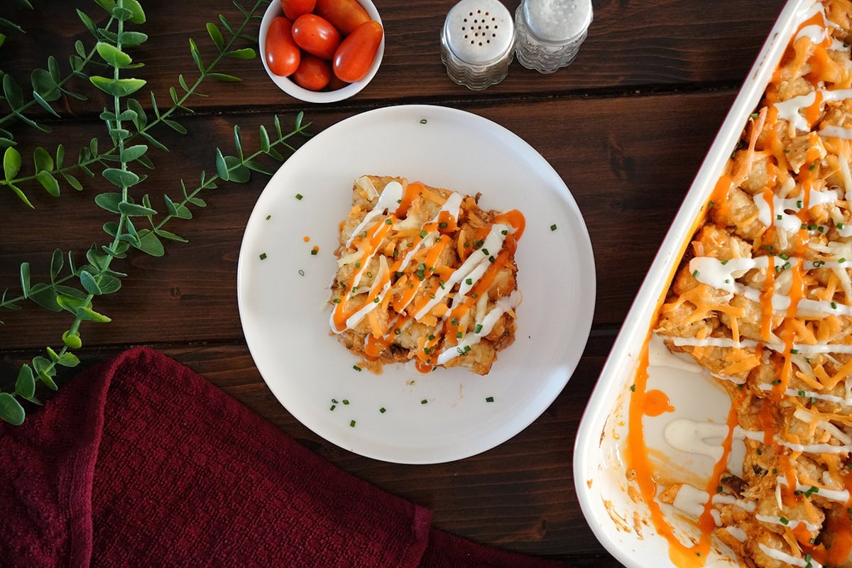 A slice of casserole with buffalo and ranch dressing drizzle.