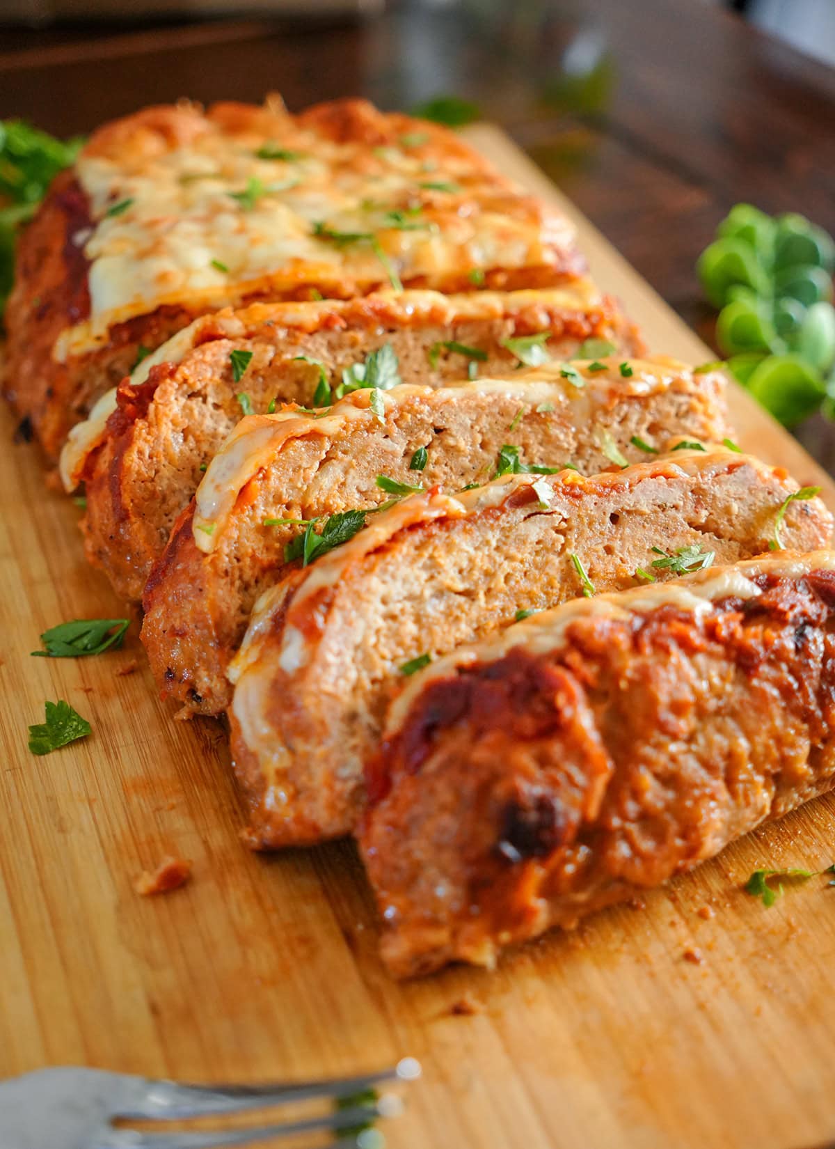 Ground chicken meatloaf with melted cheese and parsley.