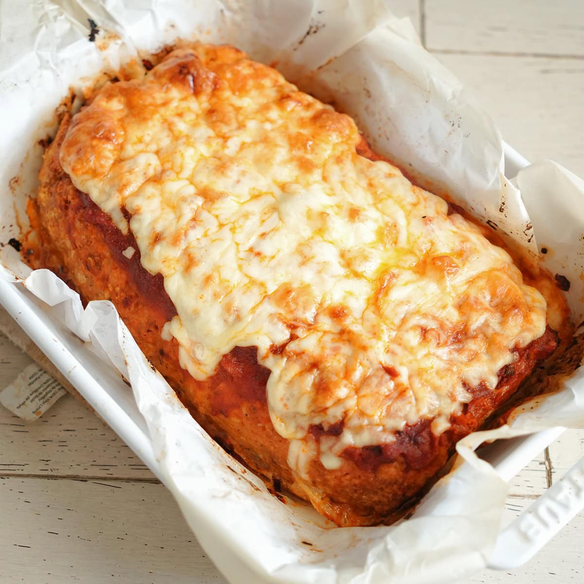 Cooked ground chicken meatloaf with melted cheese and marinara.